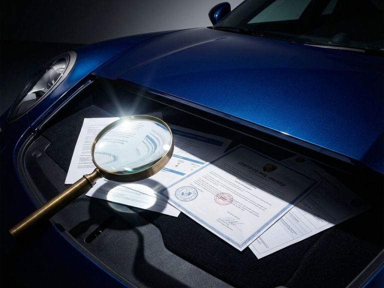 Luxe supercar met vergrootglas over voertuigdocumenten en servicerapporten op donkere ondergrond