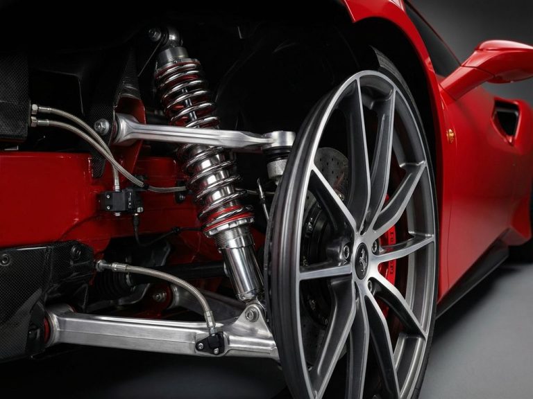 Close-up van rode Ferrari sportwagen wiel met adaptieve vering, chrome dempers en precisie-onderdelen
