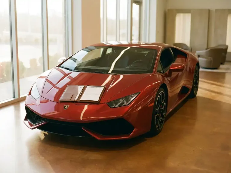 Rode Lamborghini Huracán in showroom met leren portfolio vol verzekeringsdocumenten op de motorkap