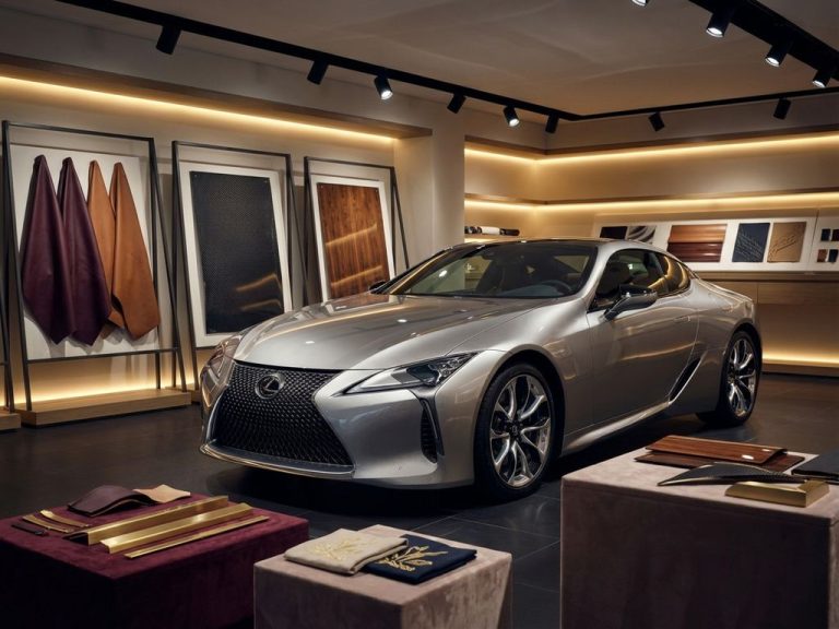 Luxe zilveren Lexus in premium autotuning werkplaats met leren samples en carbon fiber panelen