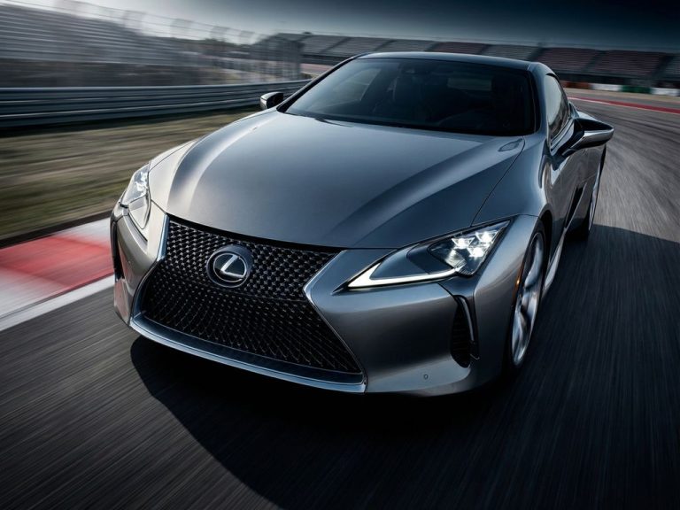 Zilveren Lexus sportwagen in extreme close-up tijdens acceleratie met bewegingsonscherpte op racebaan