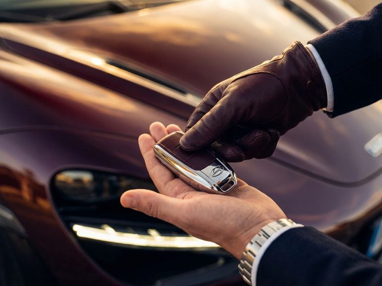 Twee handen wisselen luxe autosleutels uit voor glanzende supercar met dramatische verlichting en chromen accenten