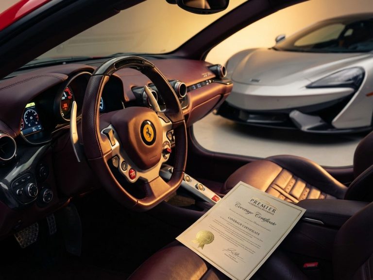 Rode Ferrari stuur en dashboard op voorgrond met zilveren McLaren op achtergrond, verzekeringsdocument op leren stoel