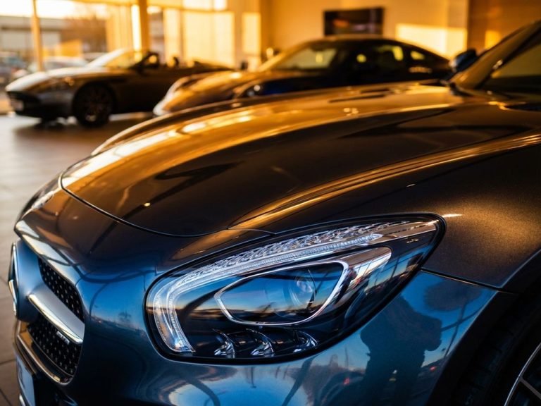 Glanzende supercar kap en koplamp met gouden verlichting in luxe showroom, spiegelende metallic lak
