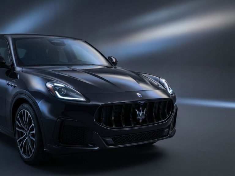 Maserati SUV vooraanzicht met iconisch drietand-grille en koplampen tegen donkere achtergrond met studiobelichting